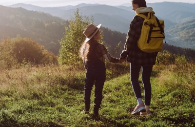 Traveler mother and little daughter standing in beautiful mountains enjoying nature