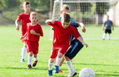 boys kicking soccer on the sports field