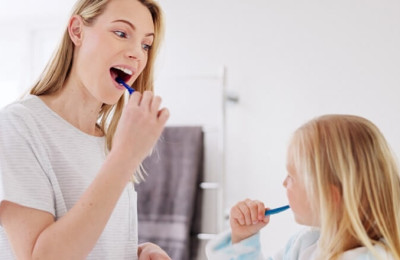 mother and daughter cleaning their teeth in the bathroom