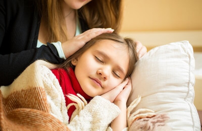 mother holding hand on sleeping daughters head, Putting her to sleep